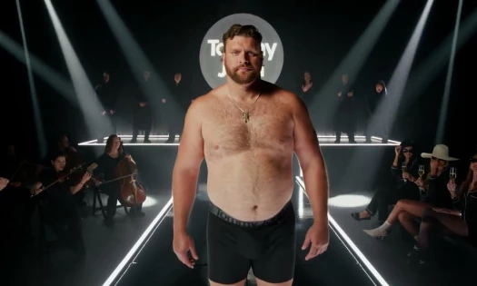 An NFL offensive lineman walks the runway with Tommy John underwear