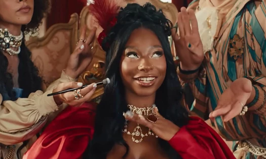 Trinity Tatum surrounded by people applying make up on her