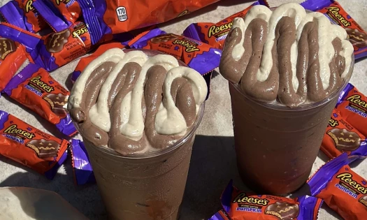 Reese's Pumpkins PB Whip Lattes surrounded by Reese's Pumpkin candies.