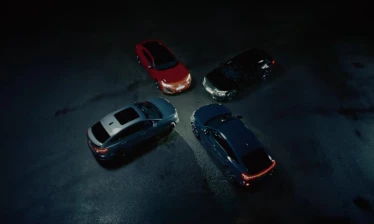 Audi's GT, Q4, A6, and Q6 e-trons on a dark, empty parking lot