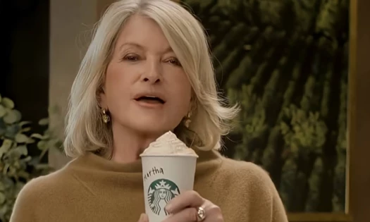 Martha Stewart holding up her Pumpkin Spice Latte from Starbucks