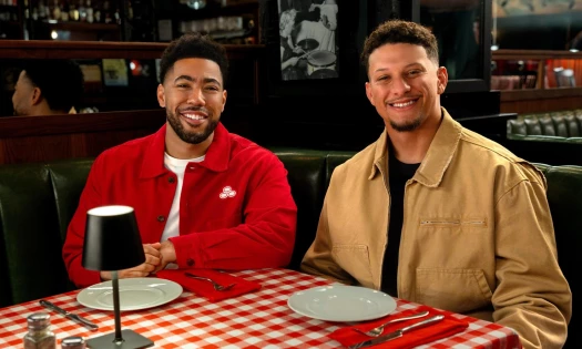 Jake from State Farm and Patrick Mahomes sitting in a restaurant.