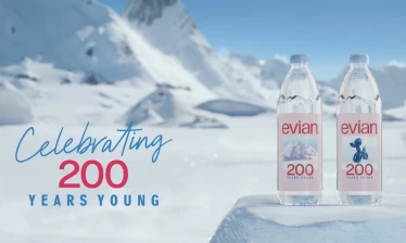 Two bottles of evian water with its "200 Years Young" slogan on the front, alongside the text "200 Years Young" in front of a Swiss Alps backdrop