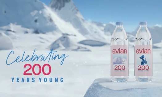 Two bottles of evian water with its "200 Years Young" slogan on the front, alongside the text "200 Years Young" in front of a Swiss Alps backdrop