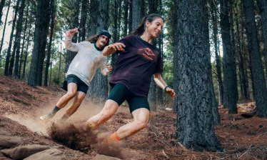 Two women running down a slope