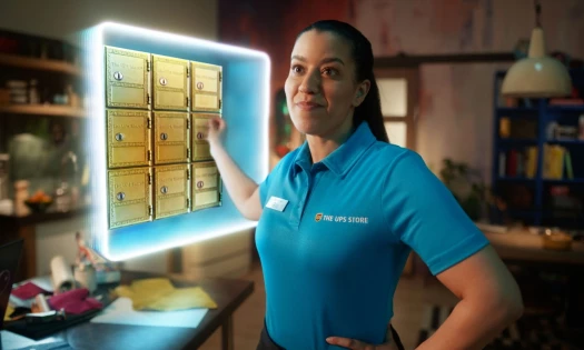 The UPS Store's brand character, Blu, opening a portal with small gold lockers.