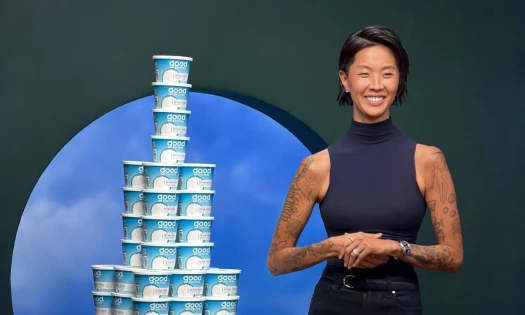 Kristen Kish poses next to a tower of Good Culture cottage cheese.