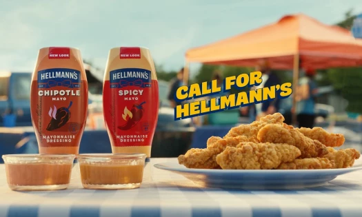 Hellmann's Real Mayonnaise on a table with a burger and other ingredients.