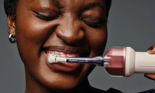 A woman brushing her teeth with the Dyson CameraJet
