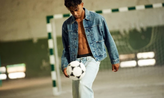 Lamine Yamal in American Eagle denim outfit playing with a football.