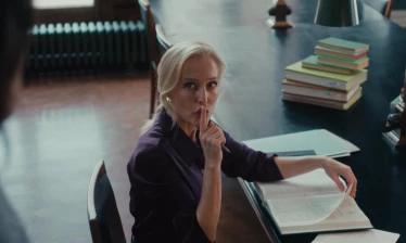 Gillian Anderson signaling someone to hush