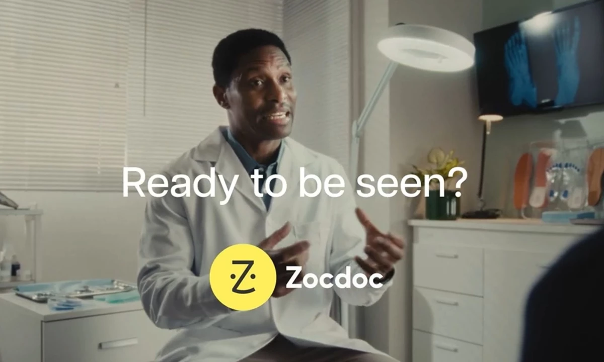 A doctor speaking to a patient off camera in his office with "Ready to be seen?" type centered on the image above the Zocdoc logo.