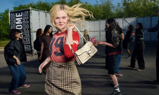 Elle Fanning with a Coach Tabby bag and models behind her.