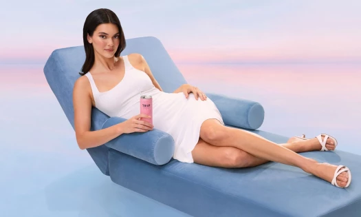 Kendall Jenner lounging on a recliner with a can of TRIP.