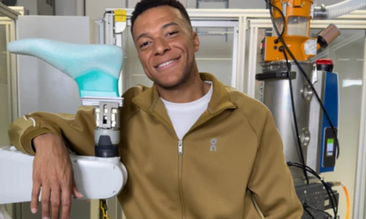 Kylian Mbappé resting his arm on a sowing machine