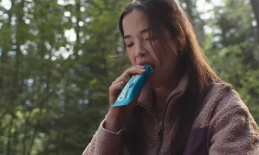 A woman biting into a Quest Nutrition protein bar