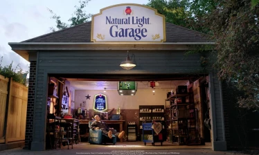 Natural Light Garage with branded signage, furniture, and "Nattytron" jumbotron.