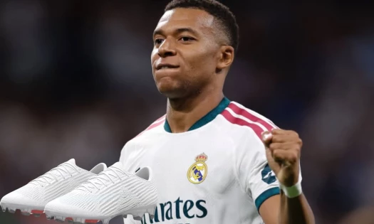 A pair of whiteout Mercurial Superfly 11 with Kylian Mbappé in his Real Madrid home jersey in the background.
