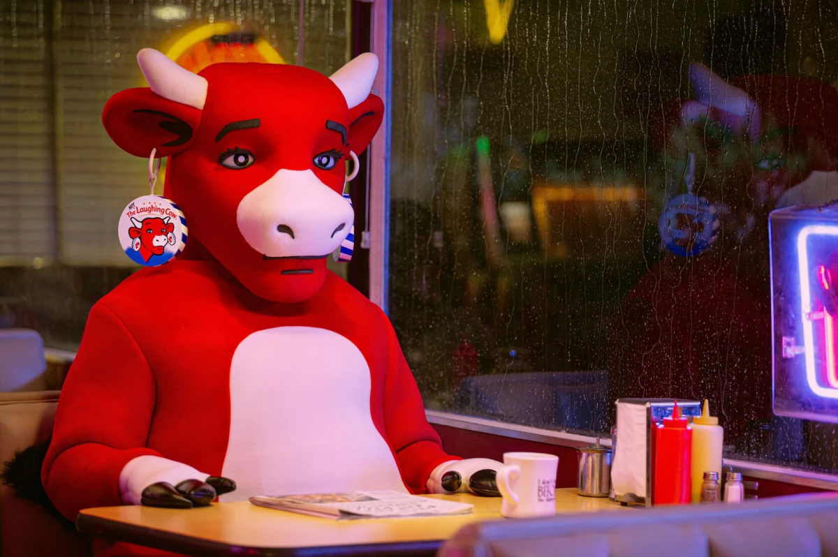 The (not) Laughing Cow sitting in a booth inside a diner
