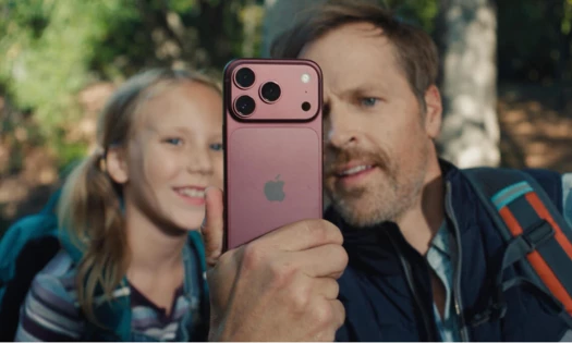 A man and his daughter looking into the screen of an iPhone 18