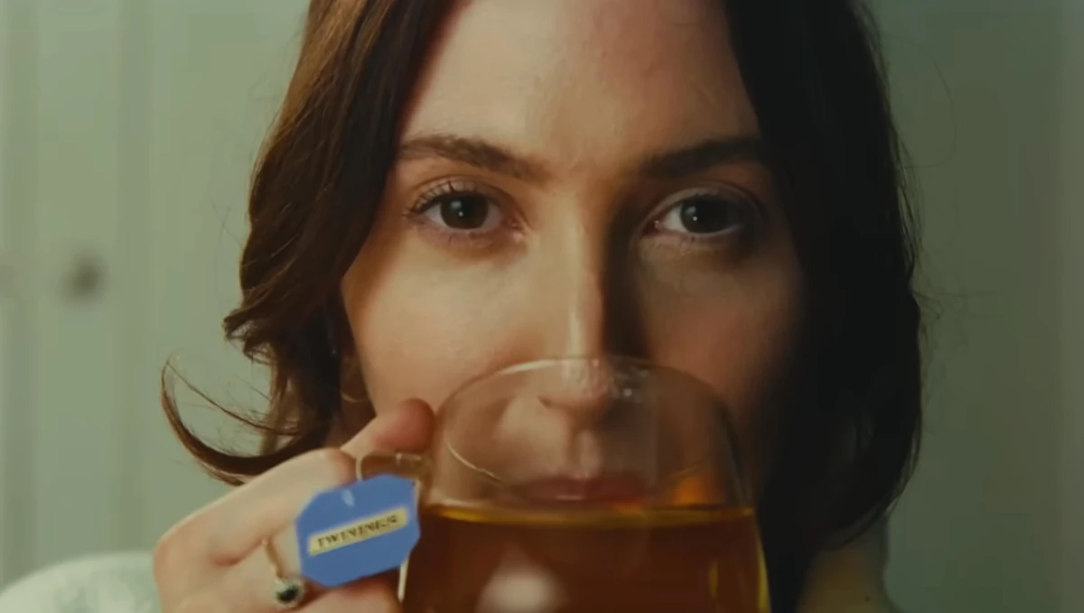 A woman sipping on her cup of Twinings tea