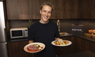 Matt Wilpers holding two plates of food from Factor.