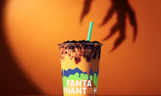 Tropical Smoothie Cafe Fanta Phantom Smoothie against an orange background with a claw hand shadow.