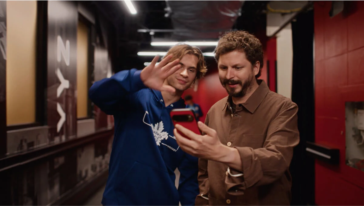 Michael Cera holding up his phone with one of the Backstreet Boys