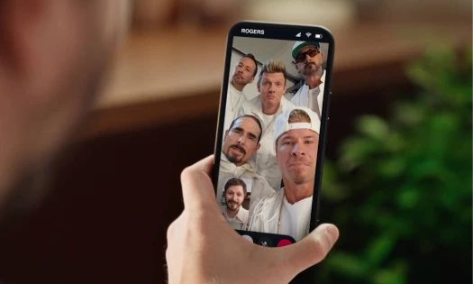 Michael Cera holding up his phone with the Backstreet Boys on a video call