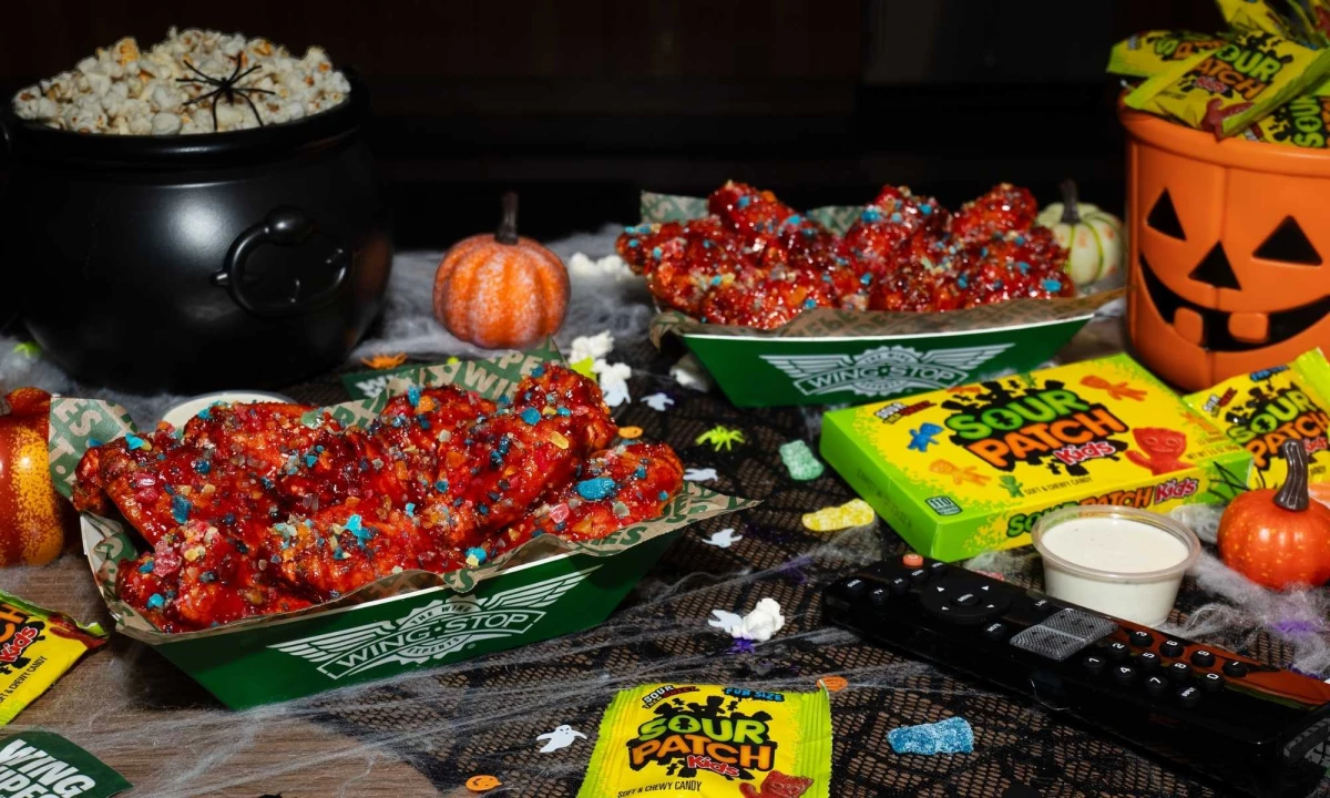 Wingstop x SOUR PATCH KIDS Wicked Punch wings surrounded by Halloween decorations.