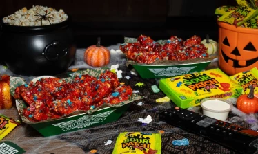Wingstop x SOUR PATCH KIDS Wicked Punch wings surrounded by Halloween decorations.