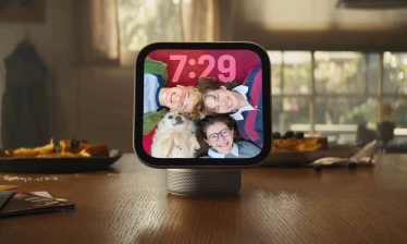 The Apple HomeView on a kitchen counter with screensaver of three kids and a dog smiling