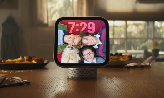 The Apple HomeView on a kitchen counter with screensaver of three kids and a dog smiling