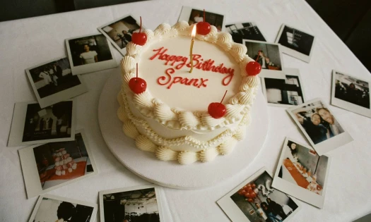 Birthday cake for SPANX surrounded by photos celebrating the anniversary.