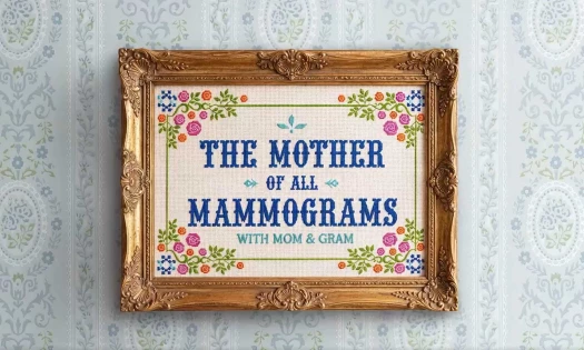 A needlepoint artwork of "The Mother of All Mammograms with Mom & Gram" framed and hung against a wall.
