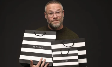 Seth Rogen holding three Sephora shopping bags.