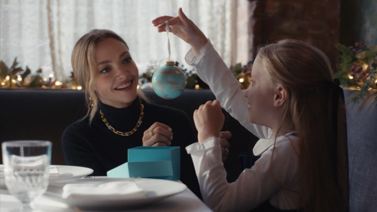 Amanda Seyfried putting Tiffany & Co jewelry on a young girl