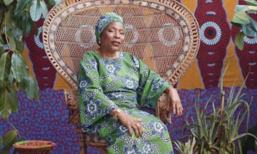 Woman sitting on a chair with an African themed background