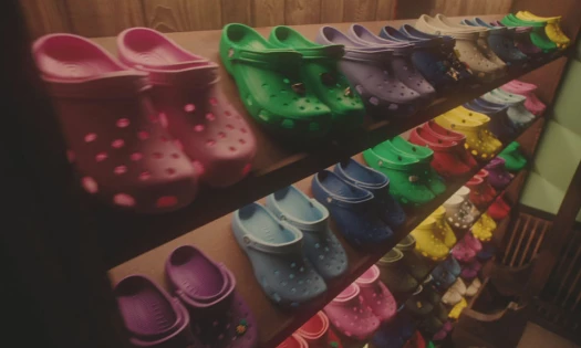 Crocs in different colors arranged in a wardrobe