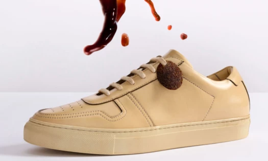 Beige sneaker being splashed with coffee