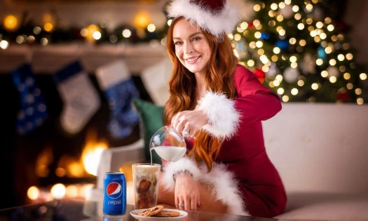 Lindsay Lohan in Santa outfit pouring milk into a glass of Pepsi