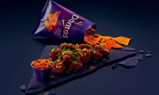 Doritos Spicy Sweet Chili package opened and displayed on a dark backgroung.