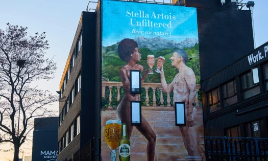 Mural of two nude people with Stella Artois beers in their hands, facing each other