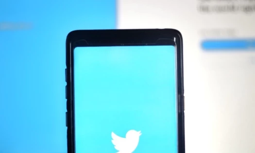 A decorative image of a smartphone scree showing Twitter logo