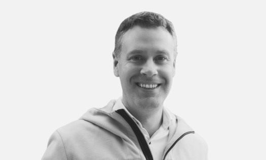 Black and white headshot of Cheq Founder, Thomas Lapham, on a grey background.