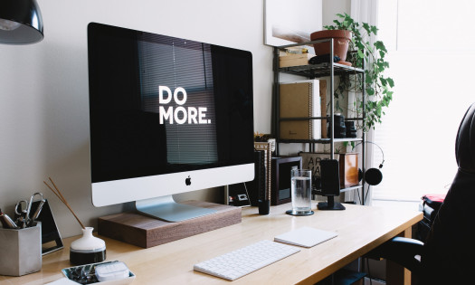 Apple desktop with "Do More" sign on black screen