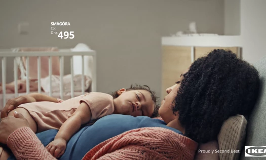 Screenshot of Ikea "Proudly Second Best" campaign with baby sleeping on mother