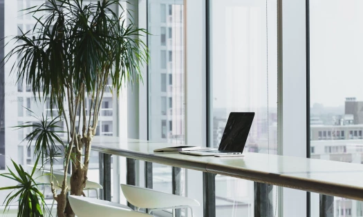 Office space with bar stool, laptop, and clear glass