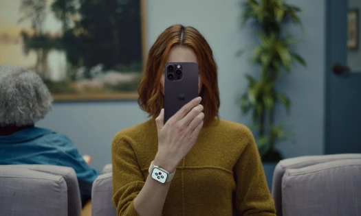 Woman holding iPhone in front of her face in doctor's waiting room