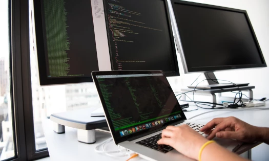 Software development work on computer and laptop screens